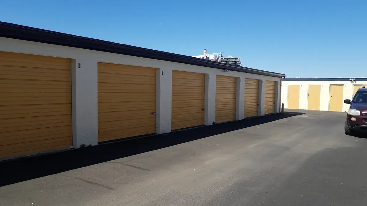 drive up storage units with an open driveway and a car parked in front