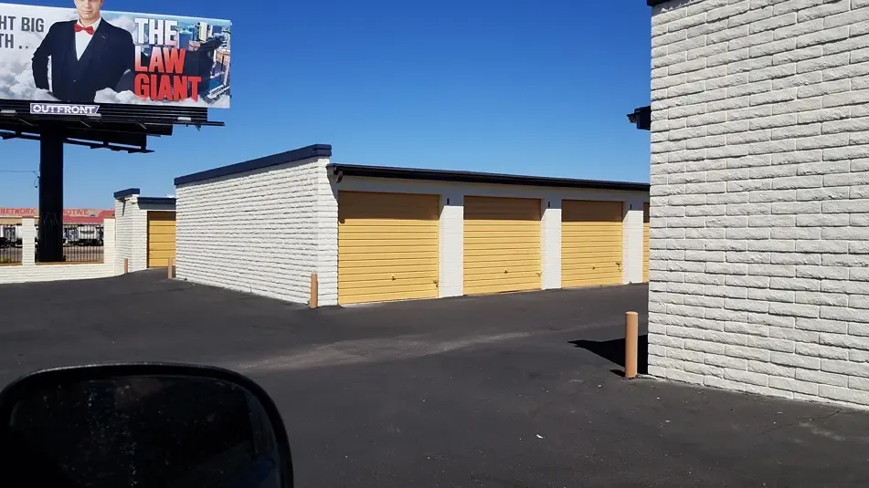 yellow drive up storage units with a billboard in the background