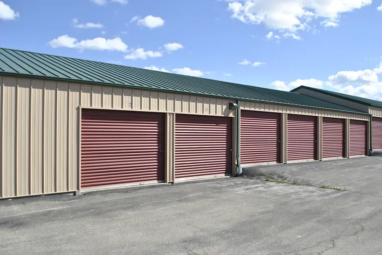 Row of outdoor storage units with overhead lights.