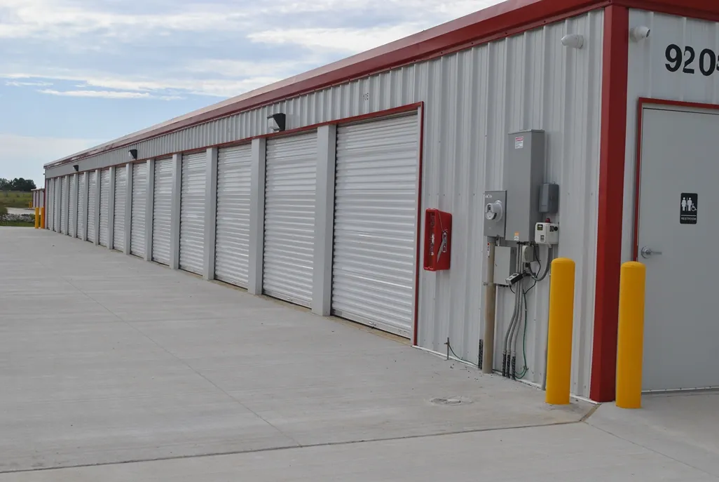 Row of outdoor storage units with overhead lights.