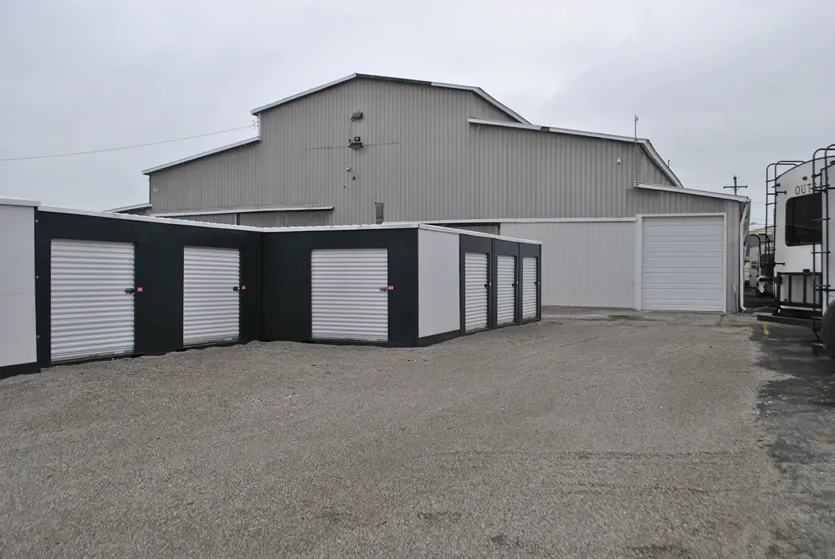 Outdoor storage units and warehouse with gravel lot.