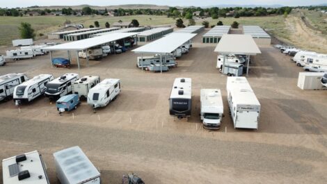 overlooking a storage facility with rv and vehicle parking covered and not covered with drive up storage units in the background