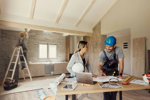 Couple Smiling while Reviewing Home Renovation Plans On Site
