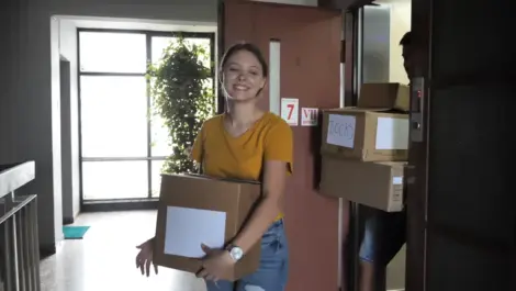 College students moving out of a dorm room and packing belongings for storage near campus
